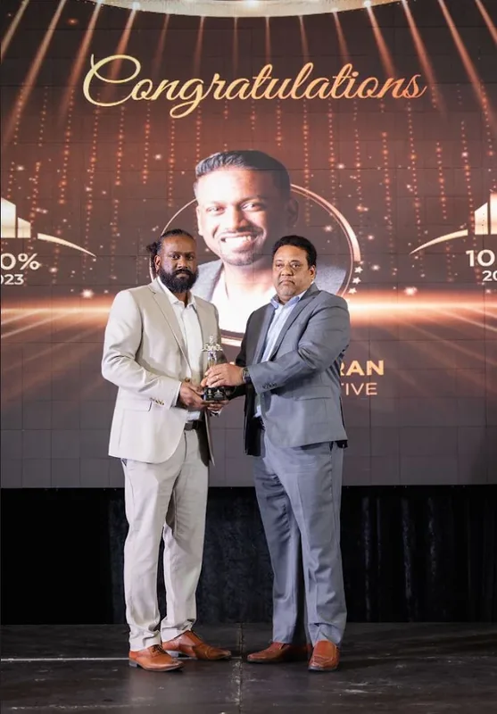 Sri Lankeswaran accepting Most Outstanding Agent of the Year, 2025 · RE/MAX Community Realty